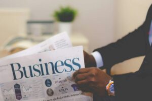 Business professional reading financial news while researching a white label partner