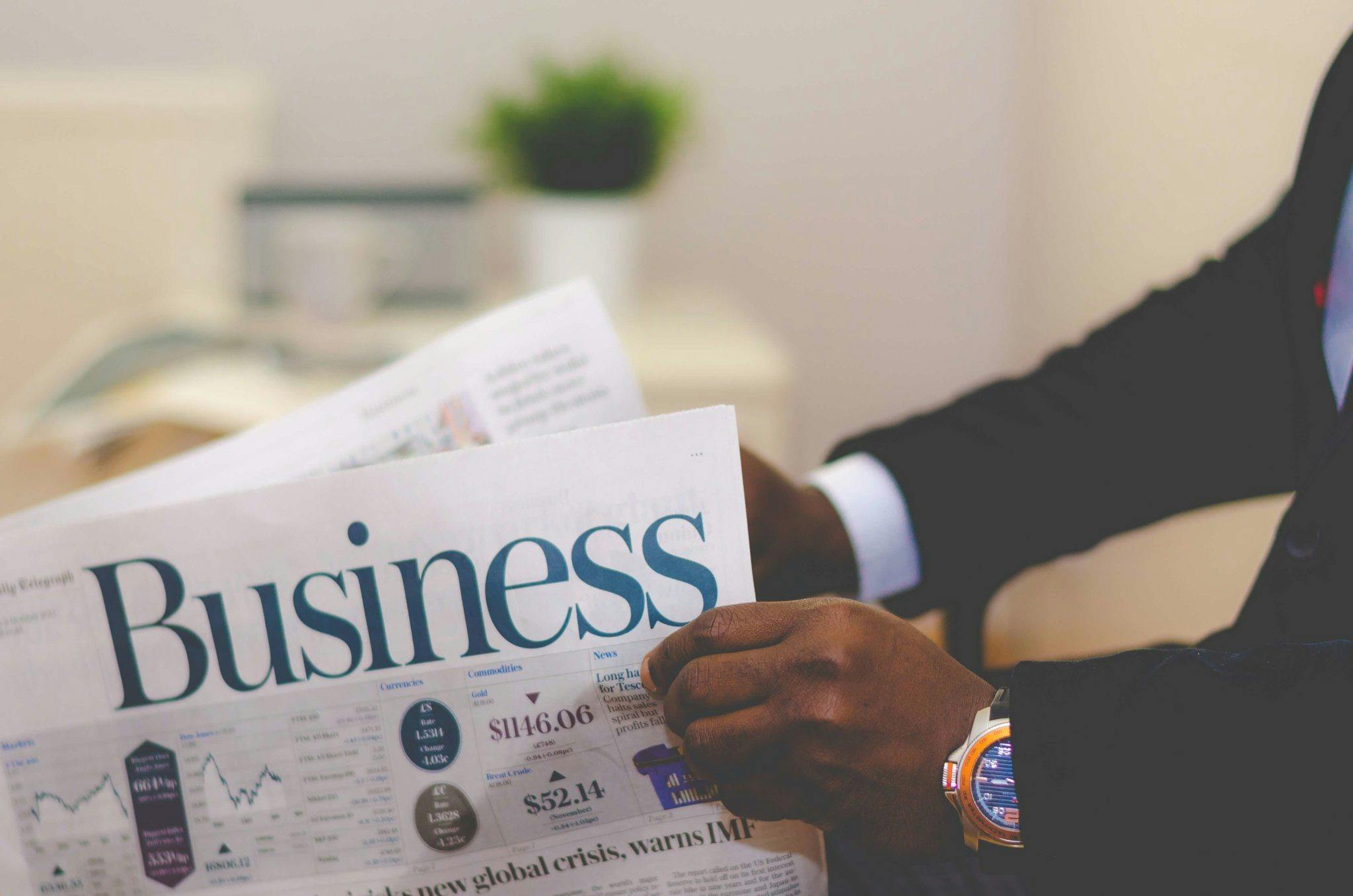 Business professional reading financial news while researching a white label partner
